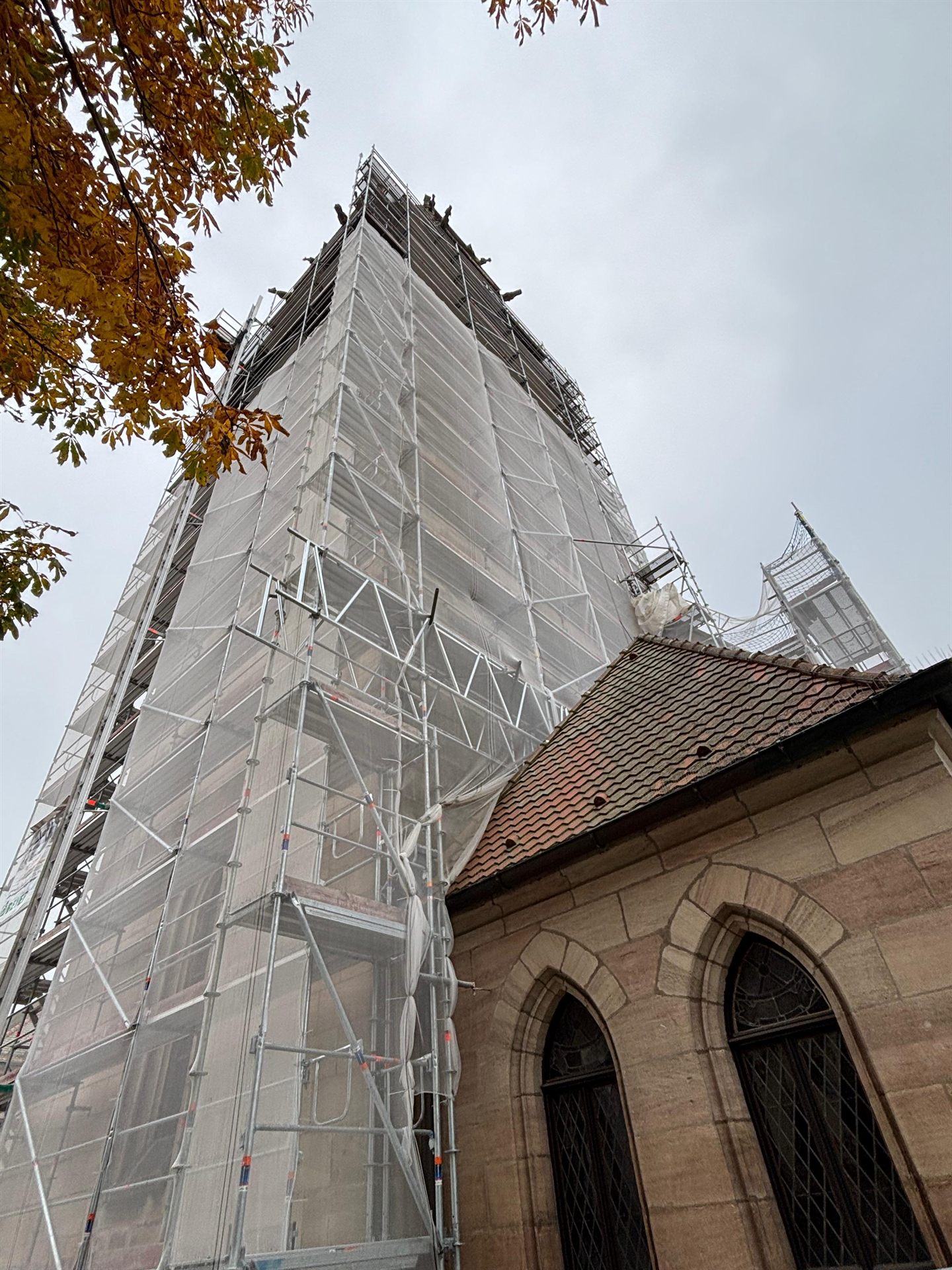 Eingerüsteter Kirchturm im Herbst