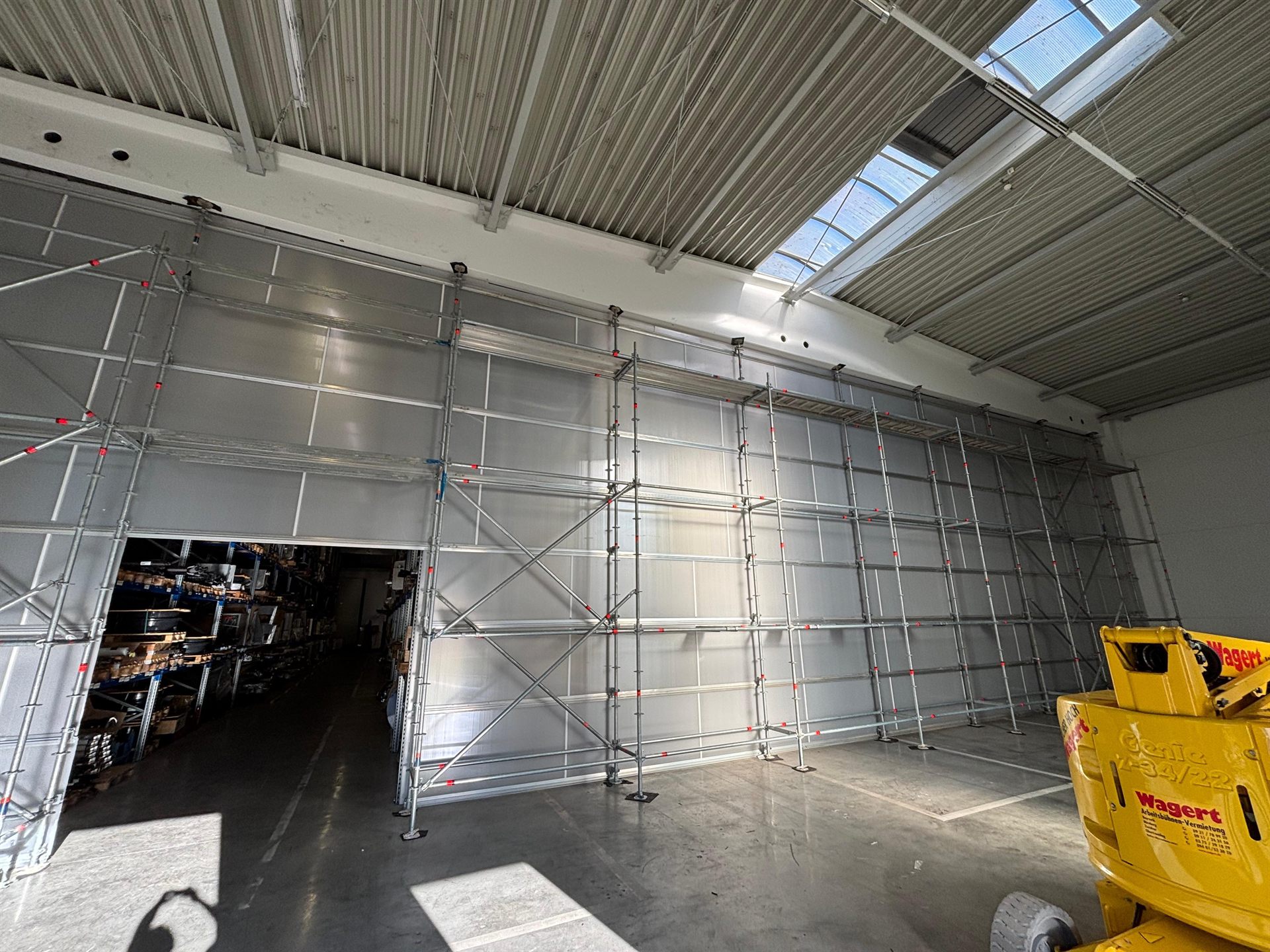 Innengerüst mit Hebebühne in einer Halle – Arbeitsplatz im Gerüstbau